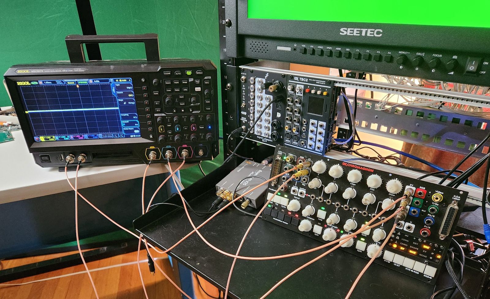 Chromagnon prototype on a test bench, cabled to an oscilloscope and a video monitor